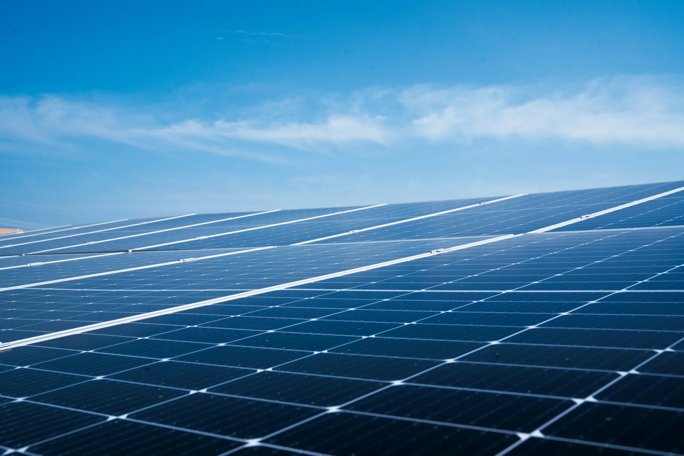 Painéis solares instalados sob céu azul com poucas nuvens