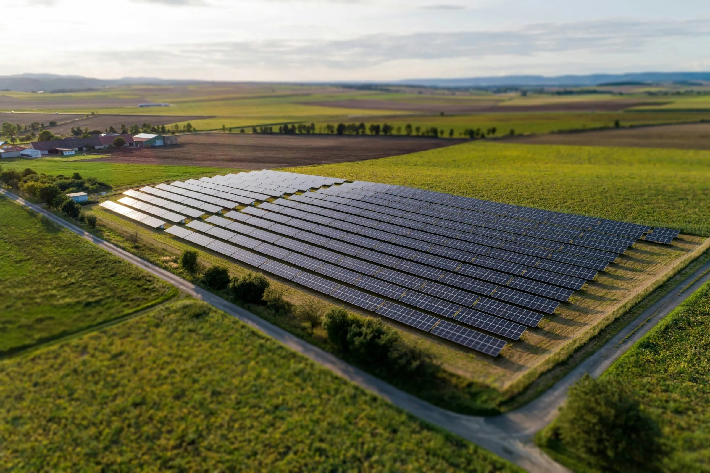 Vista aérea de uma usina solar instalada entre plantações em uma propriedade rural